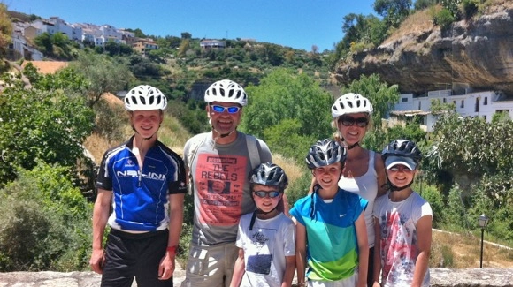 family cycling in the white village of setenil